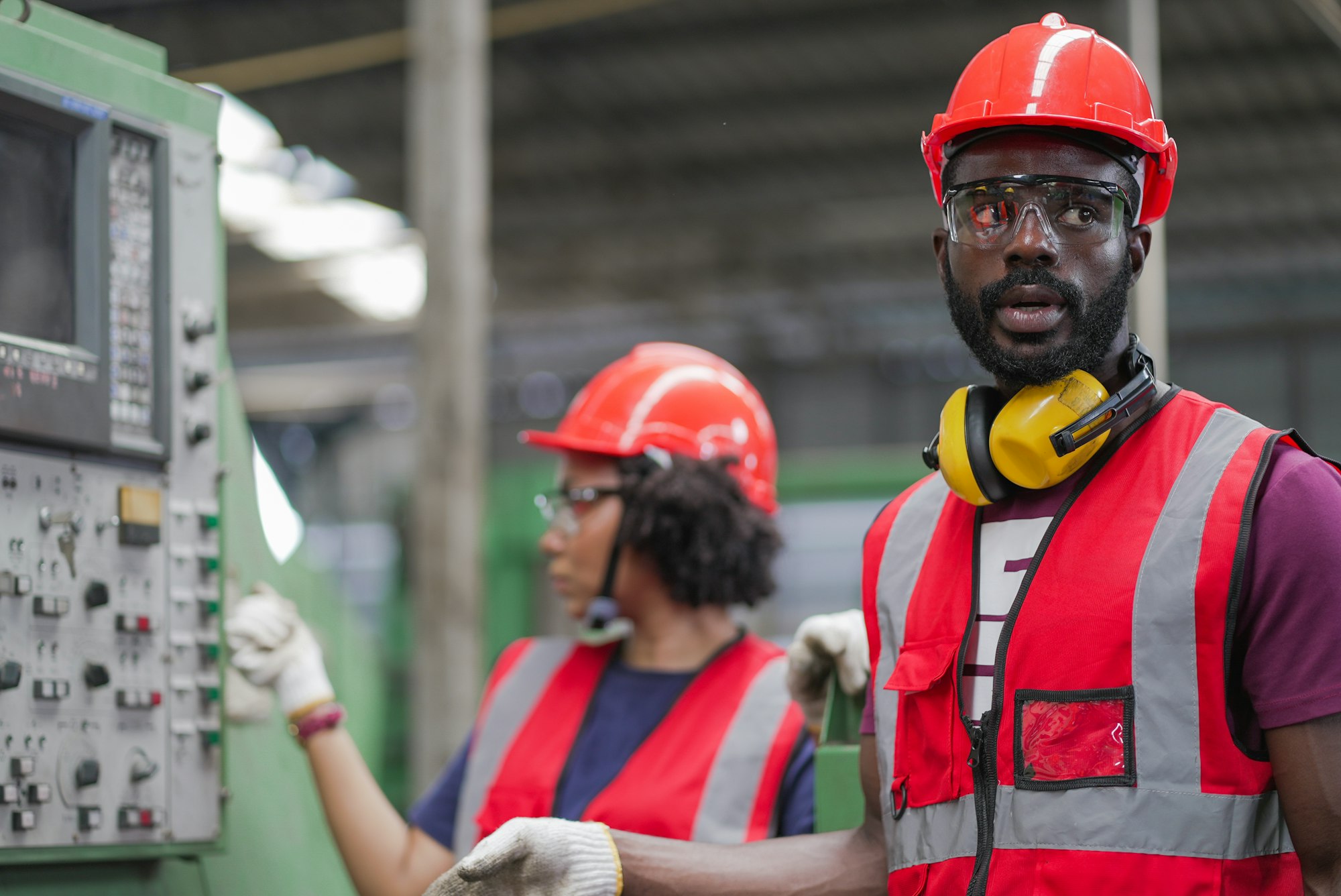 Mechanic workers in safety uniform working at industrial factory